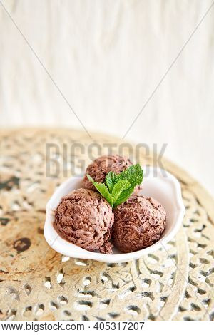 Chocolate Ice Cream With Mint Leafe. Three Balls In A White Bowl On A Vintage Table.
