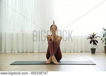 Young Woman Practicing Eagle Asana In Yoga Studio. Garudasana Pose