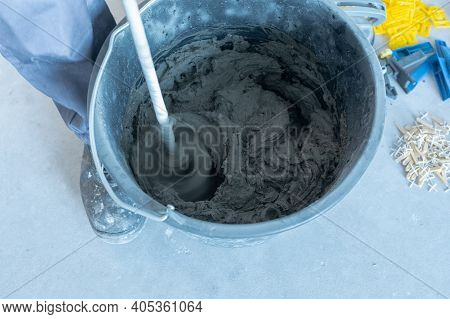 The Man Mixes The Mortar With A Perforator With A Special Nozzle. The Process Of Preparing Tile Adhe