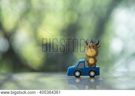 Cute Doll Ox On Wood Car As Symbol Of New Year. Concept Of Go To Year Of The Ox
