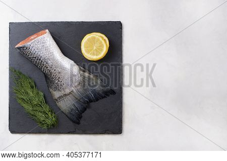Fresh Raw Salmon Tail Fillet Part With Lemon, Dill Served On Black Stone Board On Light Background. 