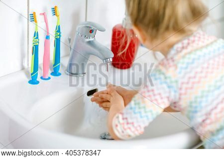 Closeup Of Little Toddler Girl Washing Hands With Soap And Water In Bathroom. Close Up Child Learnin