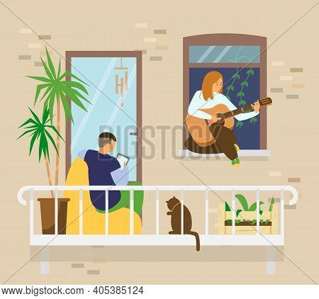 Young Couple With Cat On Balcony. Man Sitting In Bean Bag Chair Using Tablet, Girl Playing Guitar Si