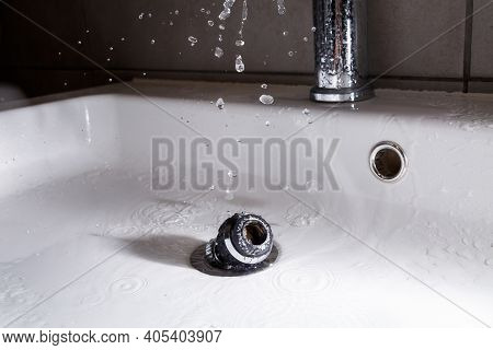 Broken Tap In The Bathroom Sink. Splashing Water From A Silver Faucet