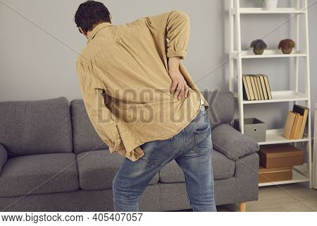 Back View Of Man With Rheumatism Feeling Intense Pain And Touching His Lower Back