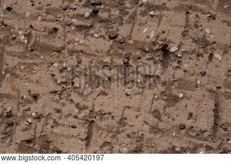 Old Retro Scrutched Yellow Brown Sandstone Wall With Sones And Pebbles Texture Background.