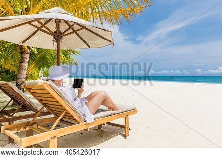 Young Woman In Hat With Tablet Pc At The Beach. Remote Work On Beautiful Beach Landscape View. Blank