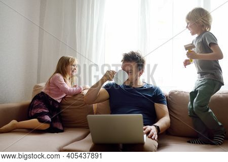 Tired Father With His Two Kids During Quarantine. Home Office Concept. Online Working And Household 