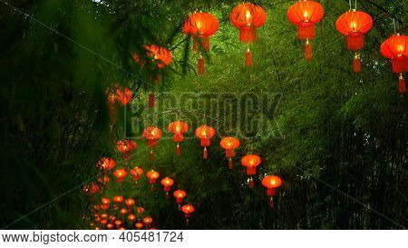 Rows Of Traditional Chinese Style Red Lanterns Hanging On Bamboo Tree Tunnel Arch.