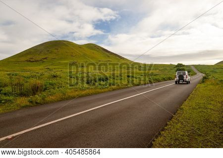 A Car Through A Road In The Middle Of The Countryside Of Easter Island, Chile