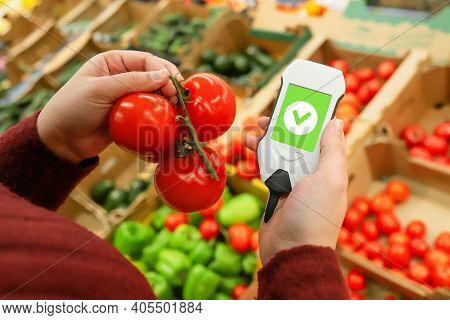 Usenitrate Tester With Ripe Tomatoes. Make Purchases In Supermarket With Device That Checks Safety O