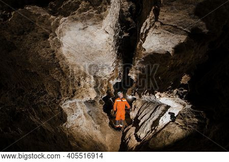 Speleologist Descend By The Rope In The Deep Vertical Cave Tunnel.