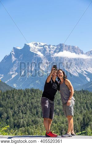 Fernpass, Austria - Aug 6, 2020: Two Female Tourists Take Selfie At Zugspitze Westside View Point