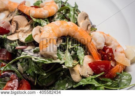 Arugula Or Rocket Salad With Prawns Or Shrimps, Tomato, Button Mushrooms, Served On A White Plate