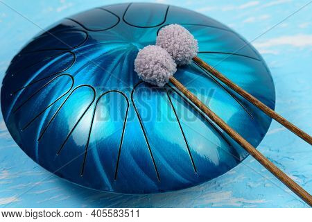 Hang Musical Instrument, Glucophone. Metal Tongue Drum, Blue Background.