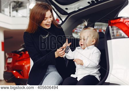 Elegant Woman With Little Daughter In A Car Salon