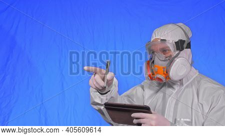 Scientist Virologist In Respirator Makes Write In An Tablet Computer With Stylus. Man Wearing Protec
