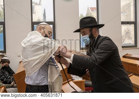 Jerusalem, Israel - January 28th, 2020: A Rabbi Helps A Man With His Tefillin In A Synagogue, Both W