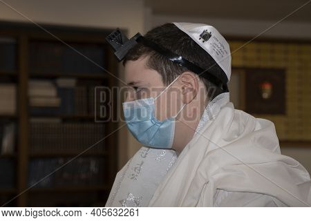 Jerusalem, Israel - January 28th, 2020: A Teenage Boy With Tefillin And A Protective Mask In A Jerus