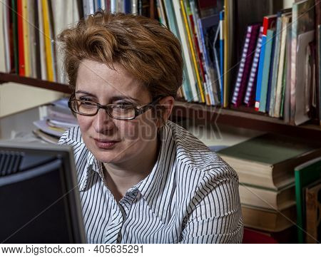 Portrait Of A Busy Woman Teleworking At Her Desk At The Home.