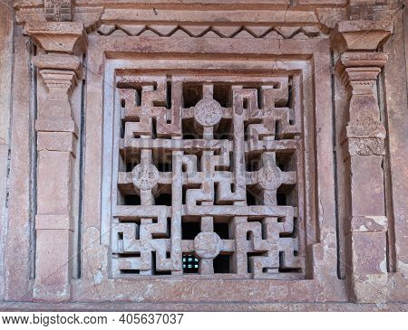 Aihole, Karnataka, India - November 7, 2013: Closeup Of Window Screen Filled With Swastikas In Bronw