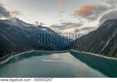 Aerial Drone Shot Of Schlegeisspeicher Resevoir With Galcier View At Dusk