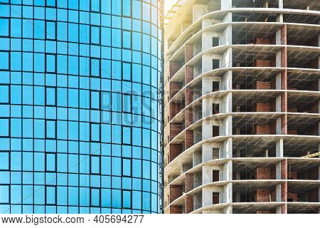 Skyscrapers With Blue Glass And Carcass At Construction Site