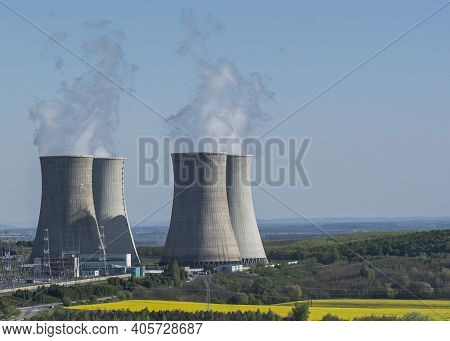 Cooling Towers Of Nuclear Power Plant Mochovce With The Yellow Field Of Rapeseed In Front Of Them.