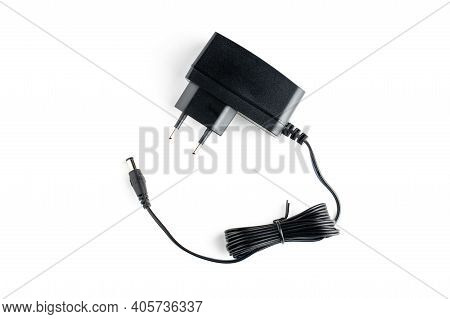 A Ac Dc Black Power Adapter Isolated On White Background. View From Above.
