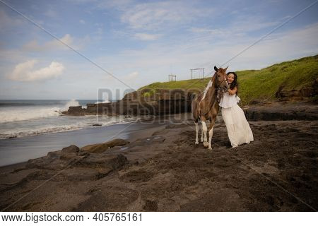 Woman Leading Horse By Its Reins. Horse Riding On The Beach. Human And Animals Relationship. Asian W