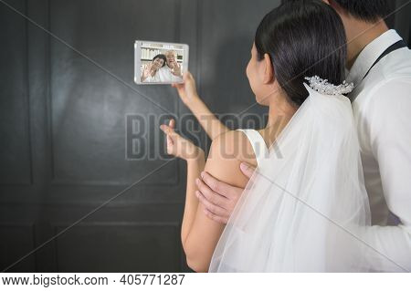 A Couple In Wedding Gown Are Making Video Call With Parents While Quarantine . Concept Of Wedding , 