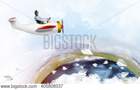 Pilot In Leather Helmet Driving Propeller Plane On Background Of Blue Cloudy Sky. Traveling Around T