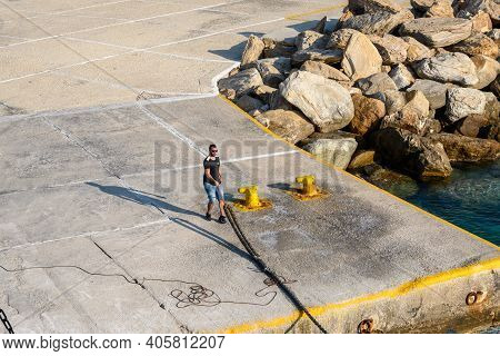 Sikinos, Greece - September 23, 2020: A Man Is Holding A Rope In The Alopronia Port Of Sikinos. Cycl