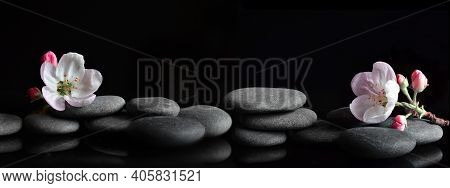 Spa Stones And Pink Flowers On Black Background. Spa Concept.