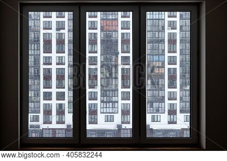 A Large Three-chamber Window With A View Of The Neighboring Skyscraper A City Landscape With Snowfla