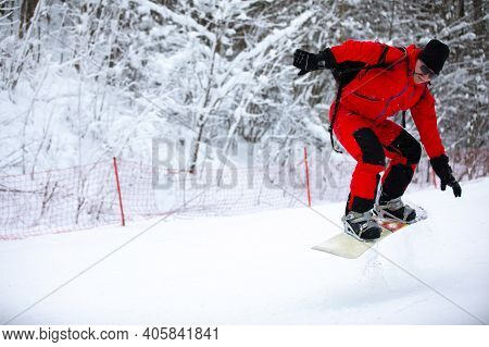 Snowboard Rider Riding Snowboard Fast Down Steep Snowy Mountain Slope, White Snow On Clowdy Winter D