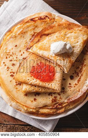 Traditional Russian Crepes Blini Stacked In A Plate With Red Caviar, Fresh Sour Creamon Dark Wooden 