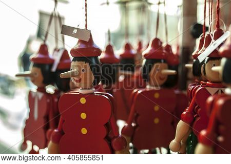 Wooden Pinocchio Puppets At Market Stall. Selective Focus