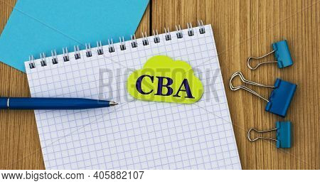 Cba (cost Benefit Analysis) - Acronym Written In A Notebook On A Wooden Background With A Pen And Cl
