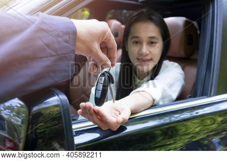 Close Up Of Dealer Giving Key To New Owner Car. New Car. Auto Dealer Giving Woman Automobile Key For