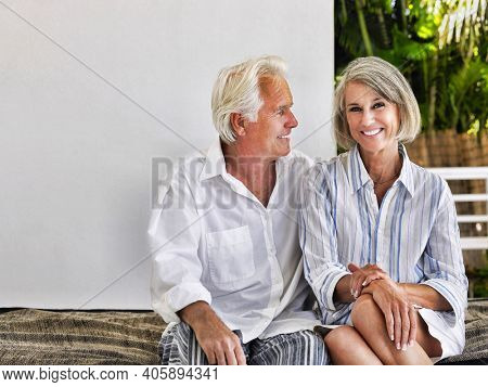 Happy middle aged couple sitting on verandah