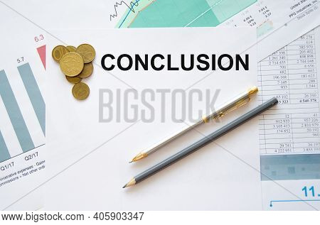 The Word Conclusion Is Written On A White Sheet Of Paper Which Lies On The Financial Chart Near Coin