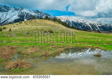 Beautiful Alpine Scenery With Small Lake And High Snowy Piatra Craiului Mountains In Background, Nea