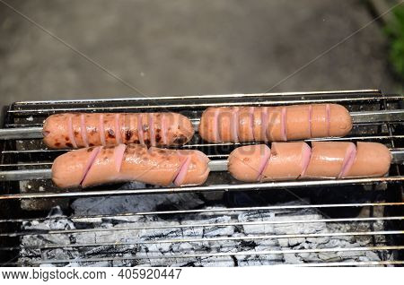 Sausages Are Cooked On A Grill On Coals . Bbq, Outdoor Barbecue .