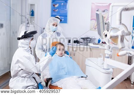 Dentist Doctor In The Course Little Kid Consultation In Dentistery Office. Stomatolog In Protectie S