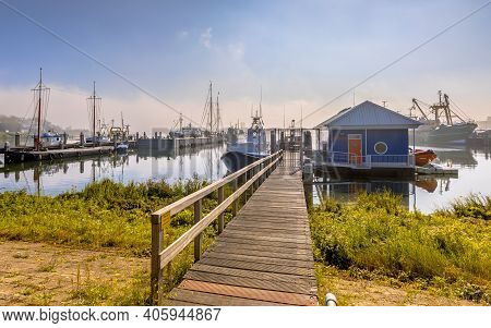Various Ships Moored In Hazy Conditions On A Wooden Quay In Harbor In Haringvliet Inlet, Zeeland Pro