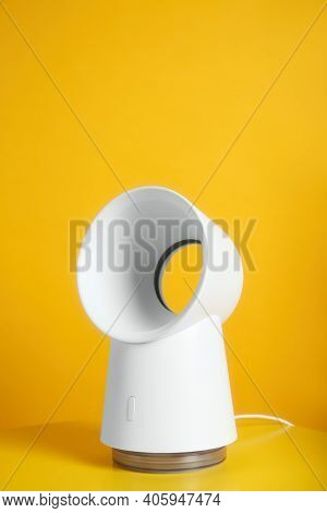 Modern Electric Fan On Table Against Yellow Background