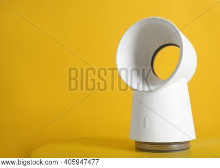 Modern Electric Fan On Yellow Table. Space For Text