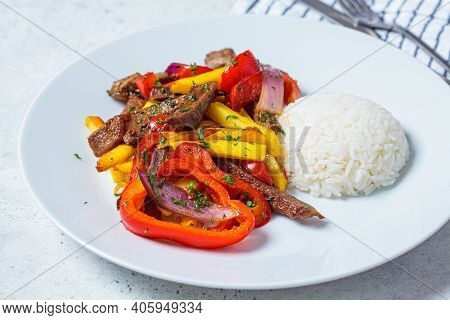 Peruvian Cuisine Concept. Lomo Saltado - Fried Pieces Of Beef With Peppers, Onions And Potatoes On A