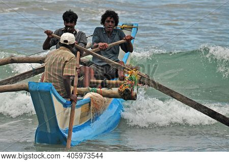 Hikkaduwa, Sri Lanka - 18 December 2011 Group Of Ethnic Men Sailing On Wooden Authentic Boat Rowing 